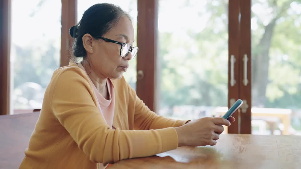 特写:女人的手指在房间里触摸手机上的滚动页面应用程序。经理独自打电话上网看电影。视频素材