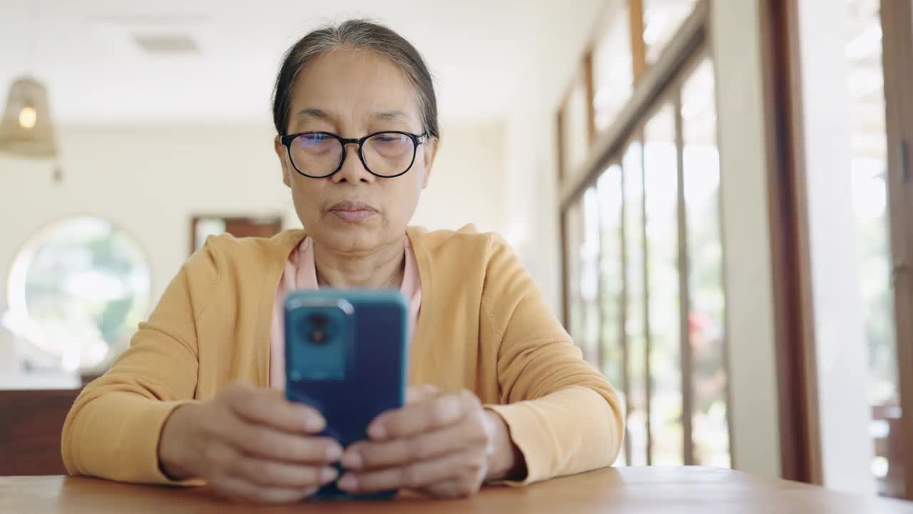 特写:女人的手指在房间里触摸手机上的滚动页面应用程序。经理独自打电话上网看电影。视频素材