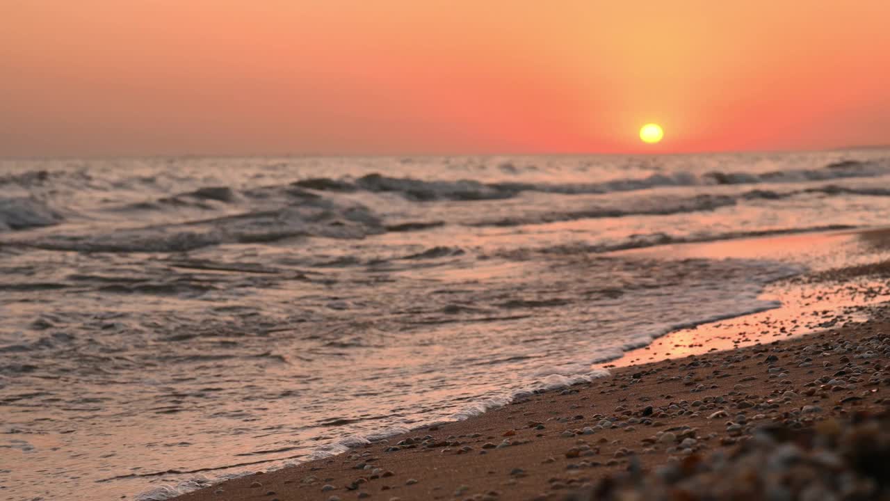 日落时的海岸。选择性地关注海滨。海的黄昏景观有小波浪视频下载