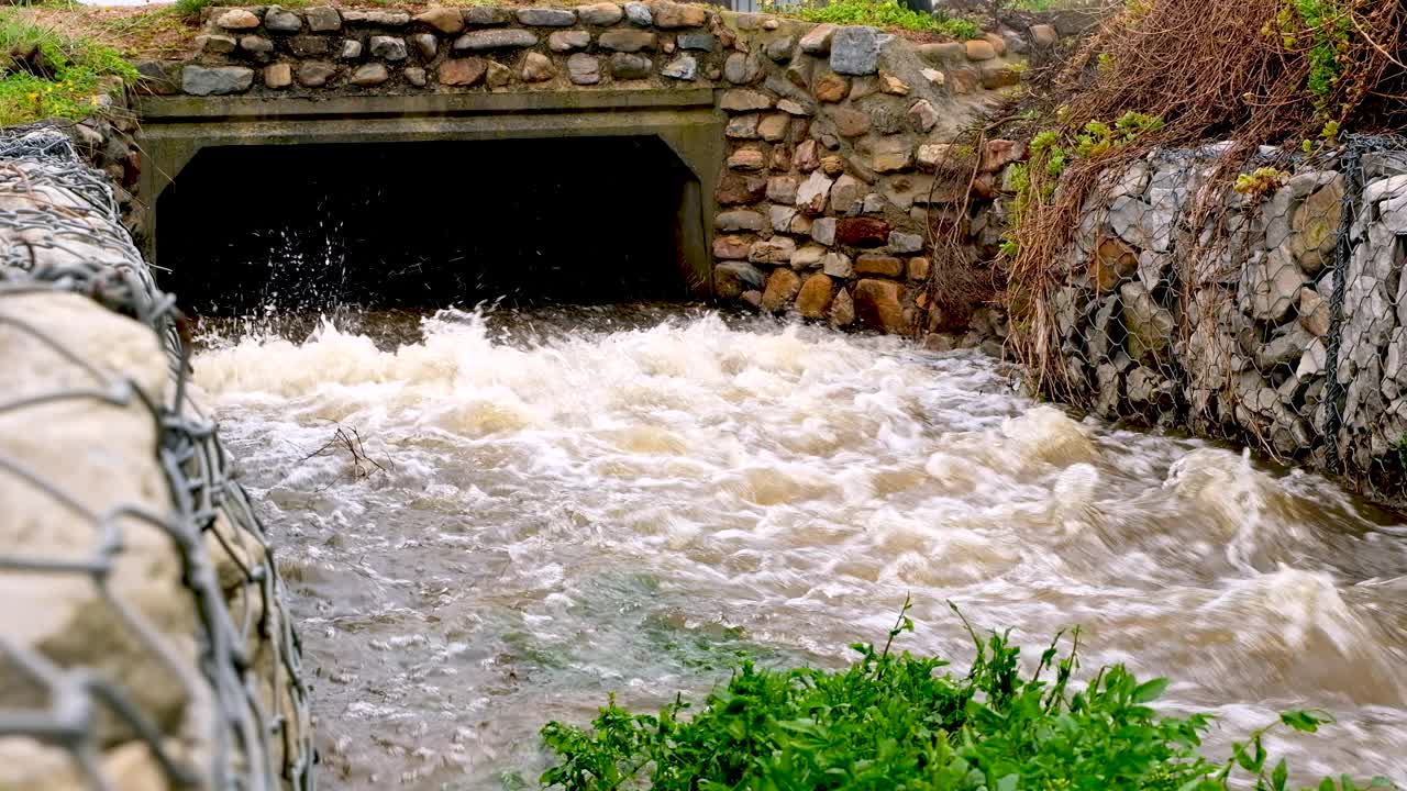 海岸线上雨水从排水沟中喷涌而出，静态实时视频素材