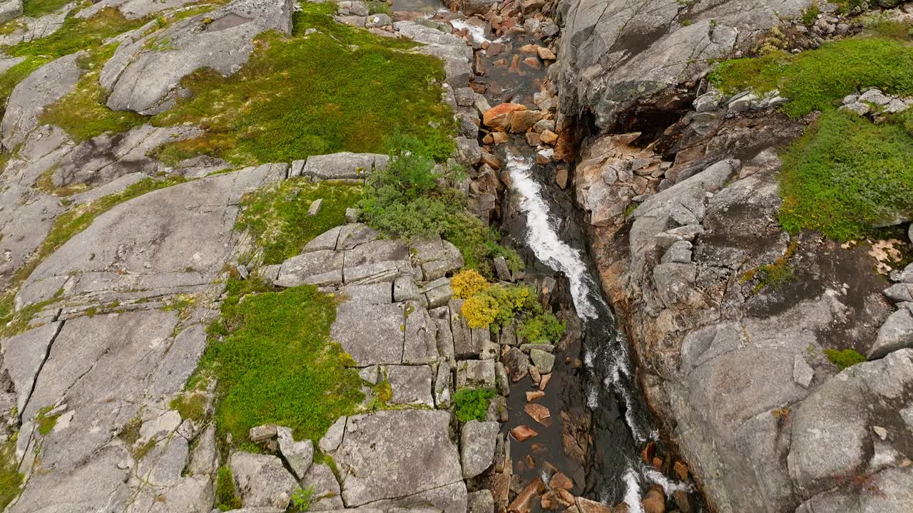 在挪威北部提斯峡湾的海尔莫峡谷山脉上流动的小溪。无人机航拍视频素材