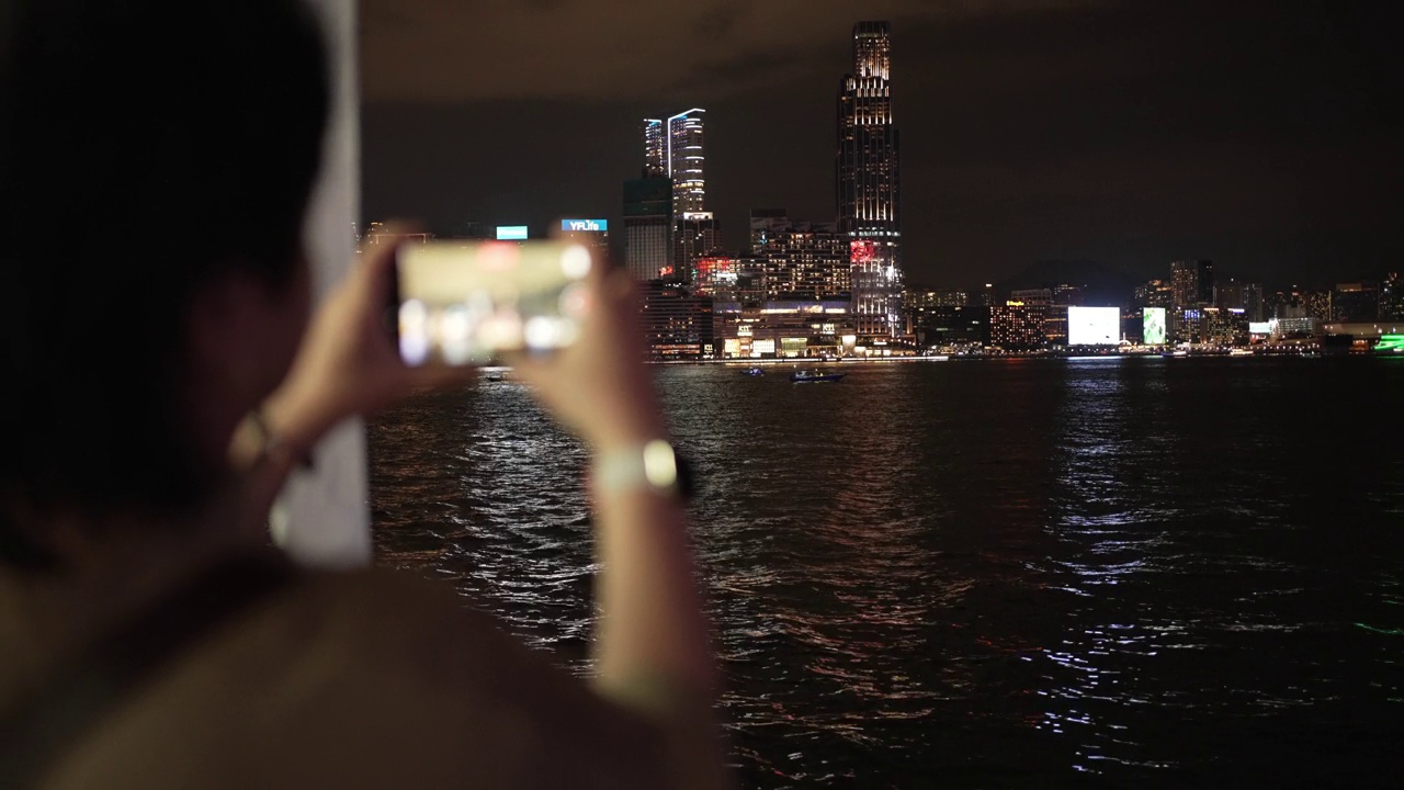 亚洲华裔女游客乘坐天星小轮穿越香港岛至九龙拍摄香港夜景视频素材