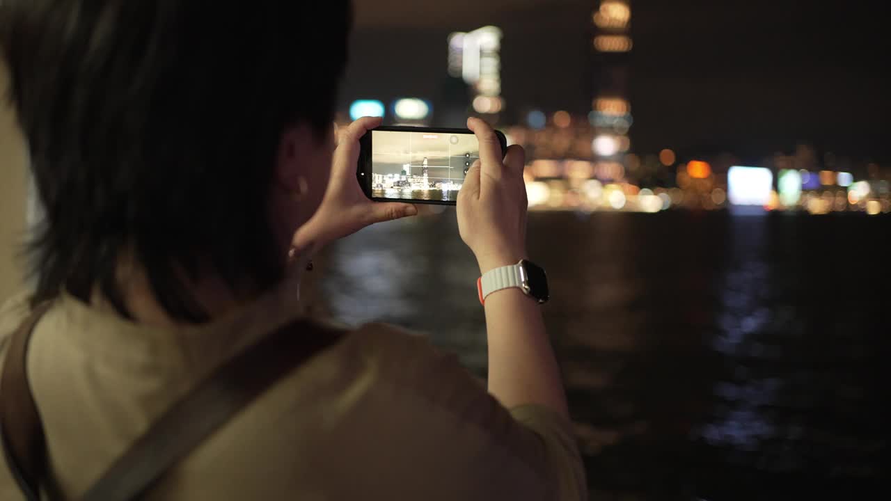 亚洲华裔女游客乘坐天星小轮穿越香港岛至九龙拍摄香港夜景视频素材