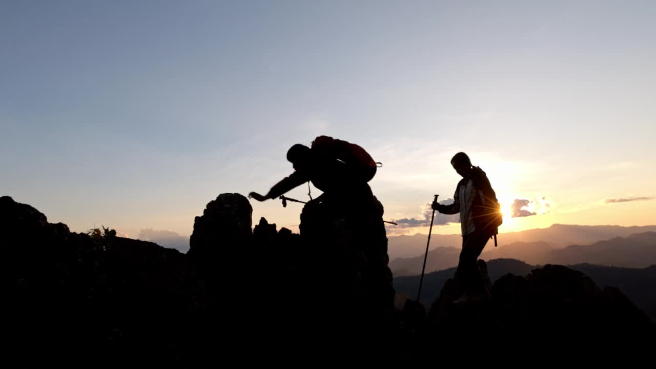 两个徒步旅行者的剪影要去山顶视频素材