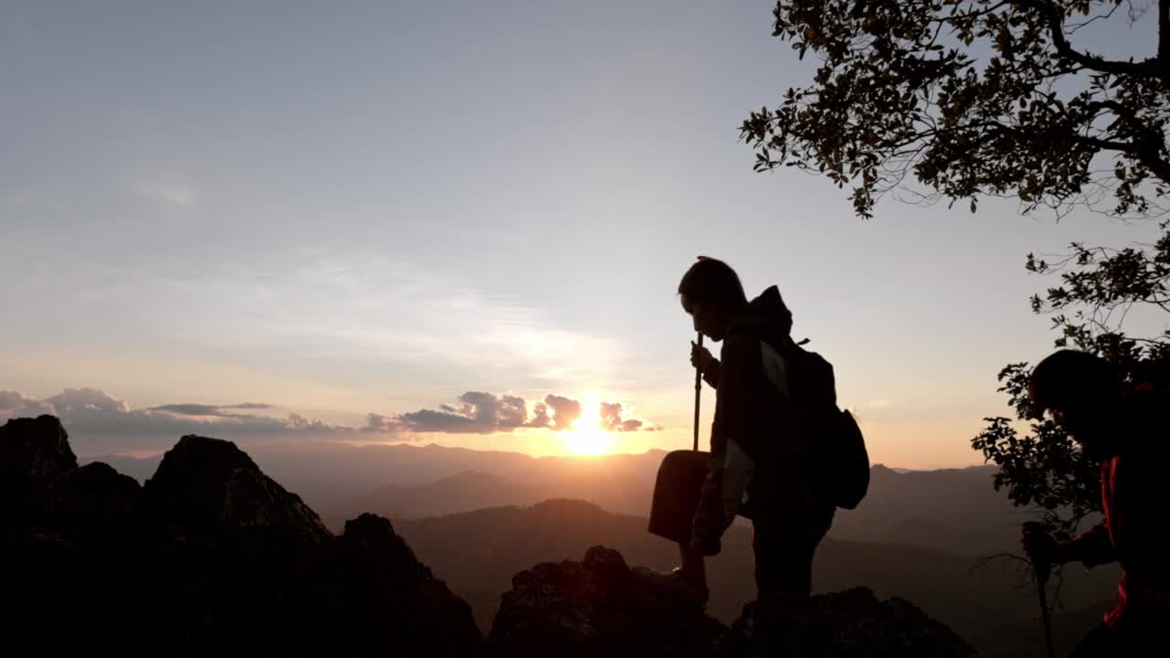 两个徒步旅行者的剪影要去山顶视频素材