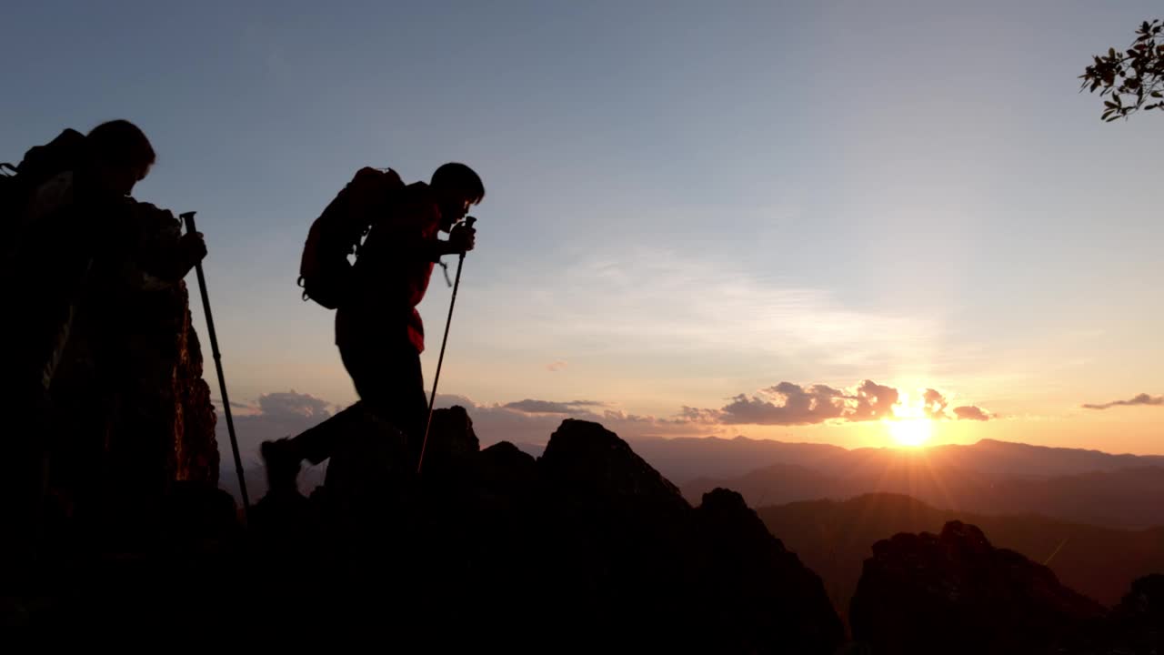 两个徒步旅行者的剪影要去山顶视频素材