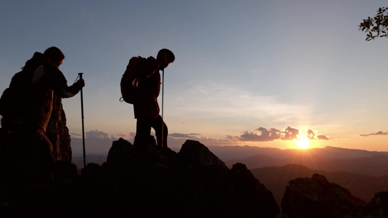 两个徒步旅行者的剪影要去山顶视频素材