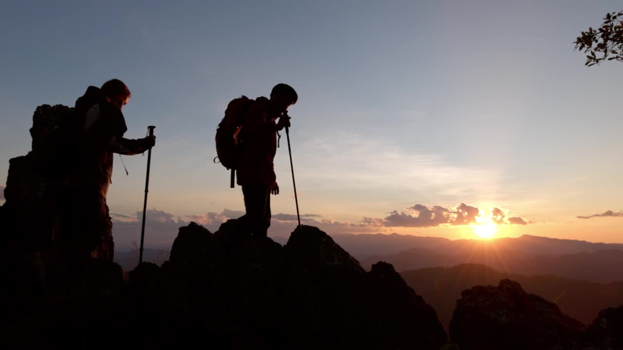 两个徒步旅行者的剪影要去山顶视频素材