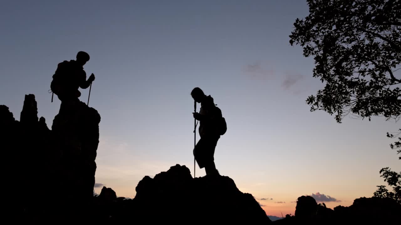 两个徒步旅行者的剪影要去山顶视频素材