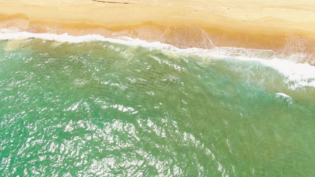 海滩景观，海浪在沙滩上破碎。视频素材