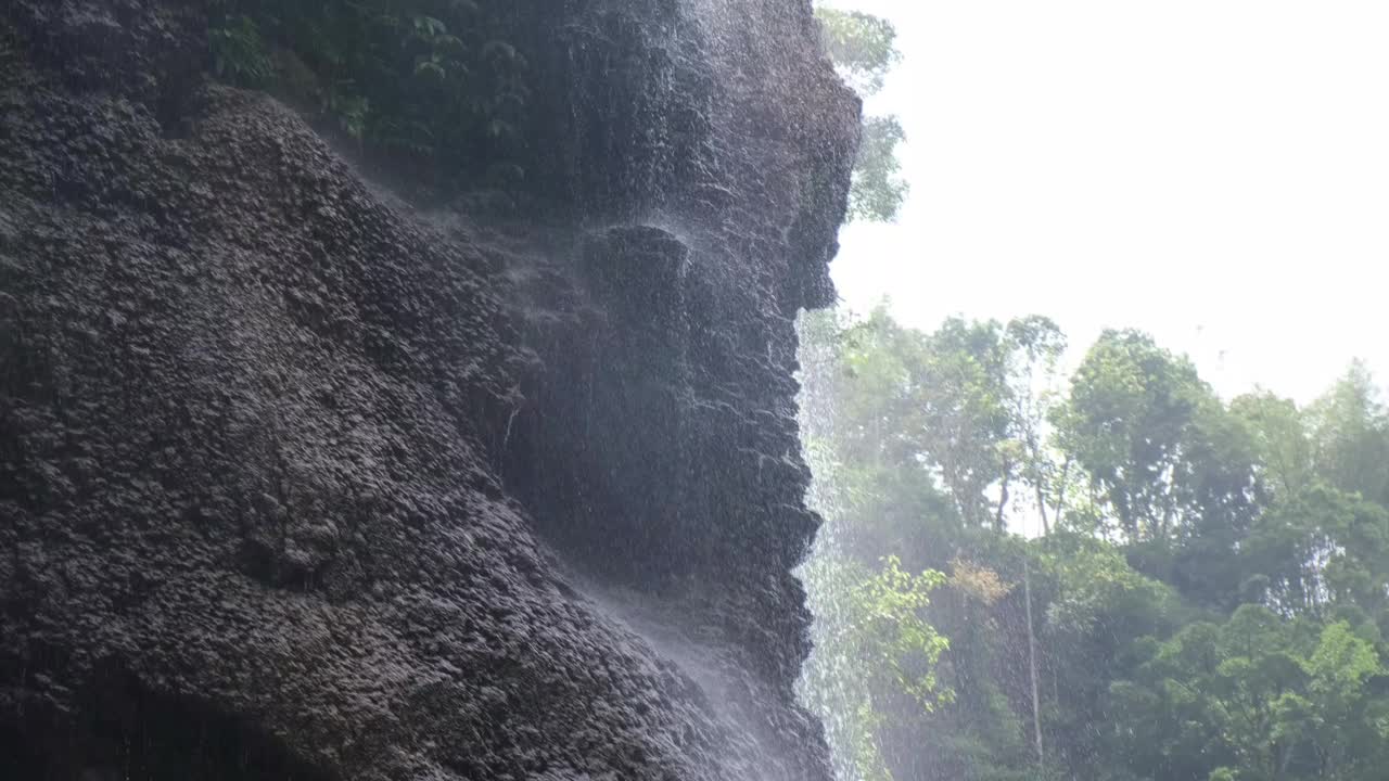 细细的瀑布落在岩石上，形成细雨般的效果视频素材