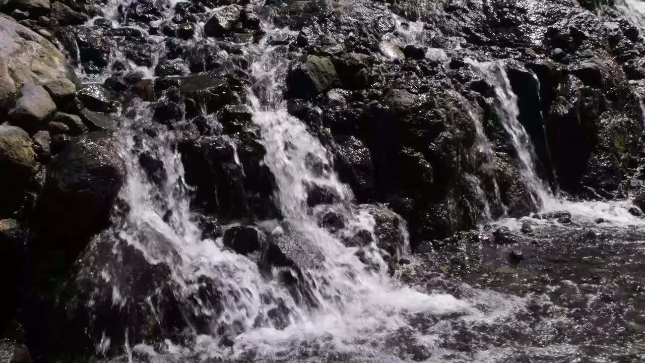 迷你瀑布水流在岩石之间以慢动作快速流动视频素材