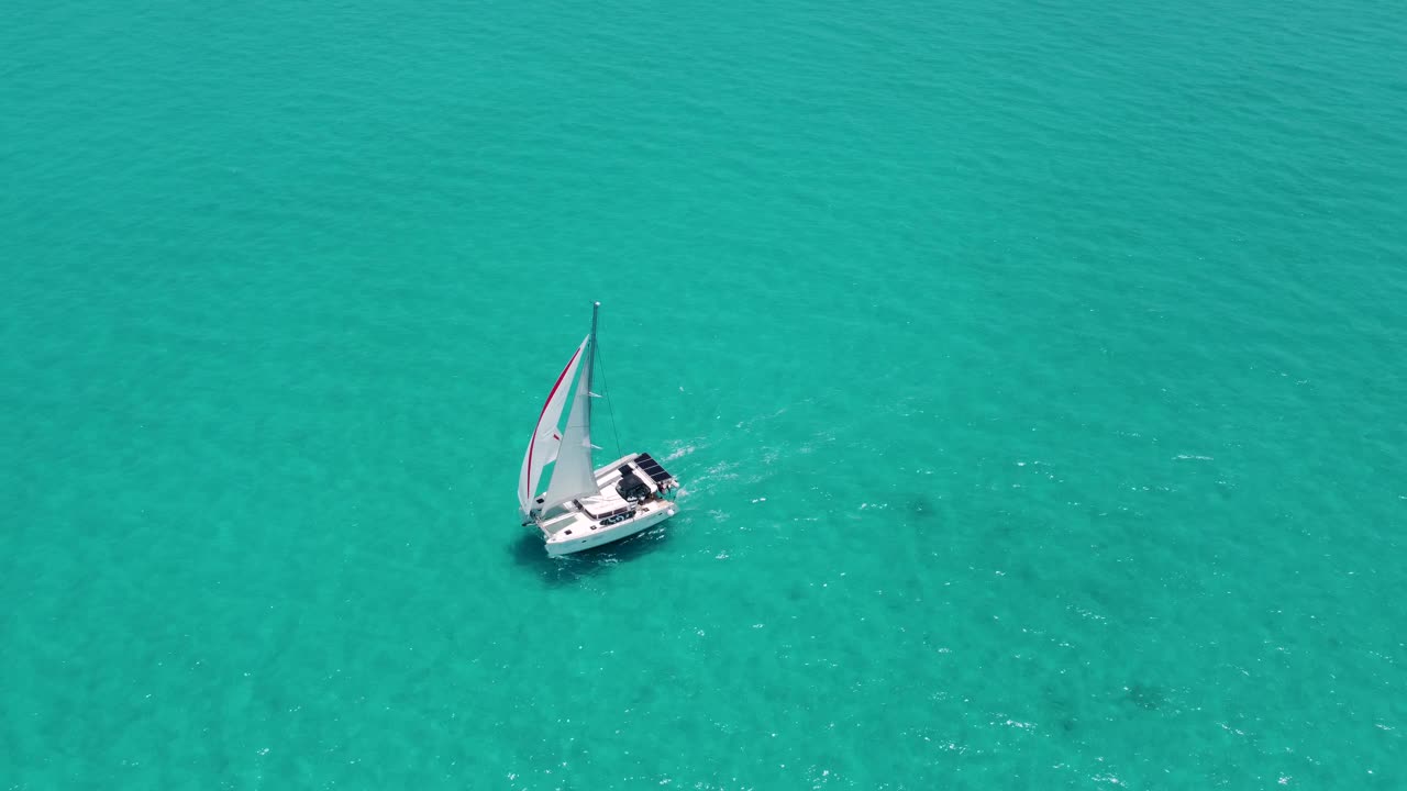 在巴哈马碧绿的海水中，一艘帆船双体船的鸟瞰图视频素材