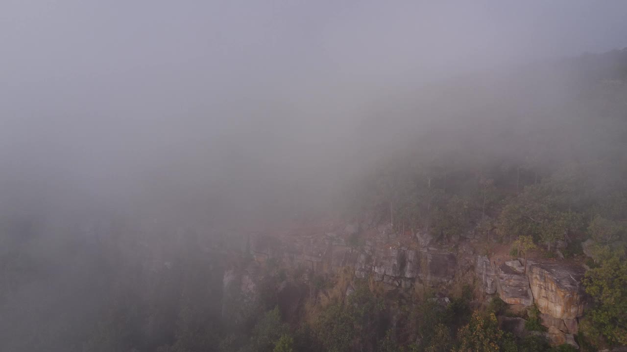 在泰国的冬季旅行中，无人驾驶飞机飞过云雾缭绕的山脉中的悬崖。自然、景观、旅游理念视频下载