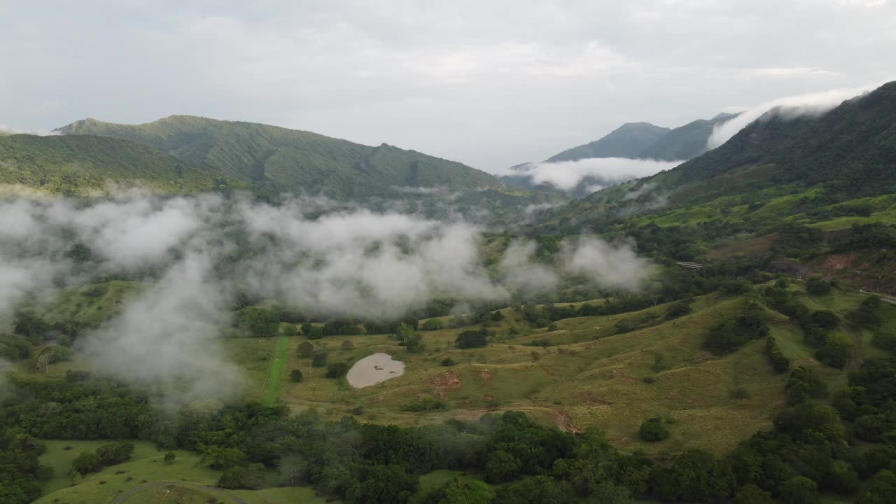 日出时哥伦比亚的大雾穿过山脉和阴雨天气，令人印象深刻。路边多云的天空，云间无人机4k视频素材