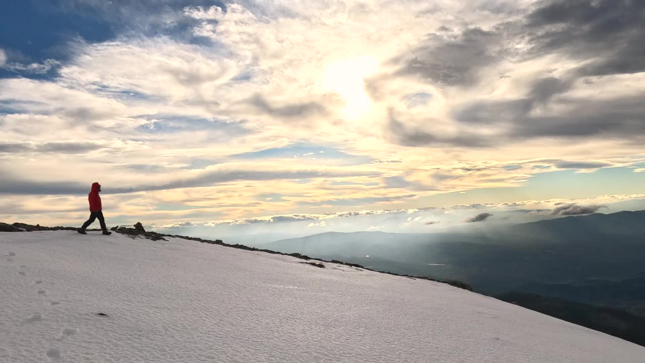 日落时分，一位女登山者正走在高海拔的山顶上视频素材