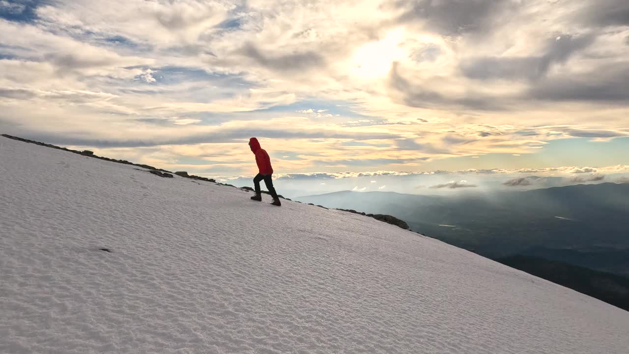 日落时分，一位女登山者正走在高海拔的山顶上视频素材