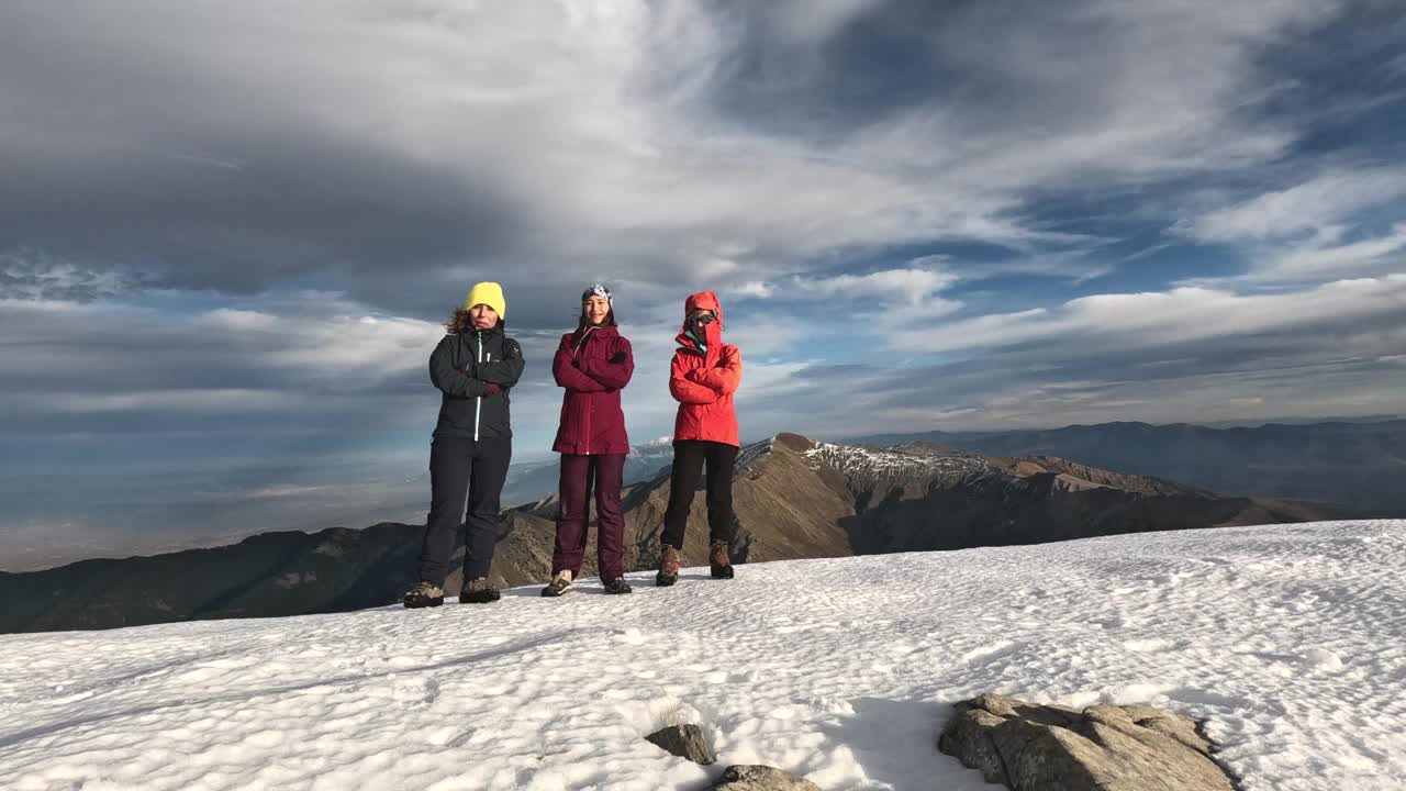 年轻的女登山队站在高海拔的山顶上，骄傲而自信地看着镜头视频素材