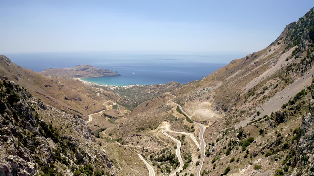 无人机拍摄的山区道路，俯瞰普拉基亚海滩和地中海，希腊视频素材