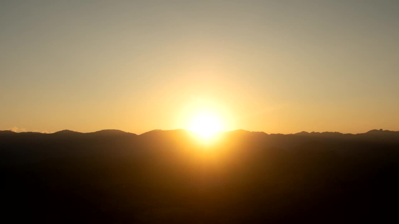 日落时间流逝，戏剧性的日落在山景和晴朗的天空视频下载