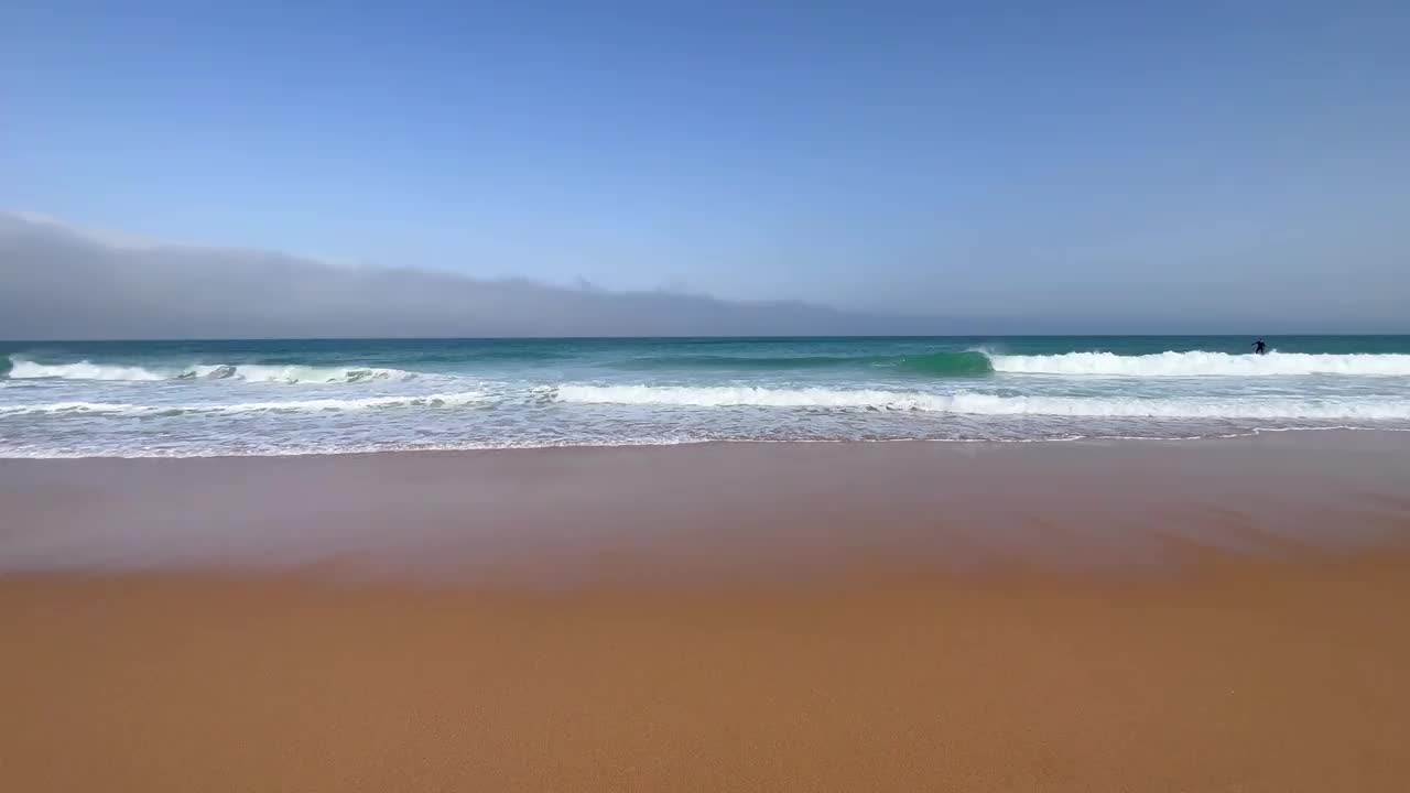 黄金时段沙滩上的小浪。暑假在海滩。蔚蓝的大海和细沙沙滩视频下载