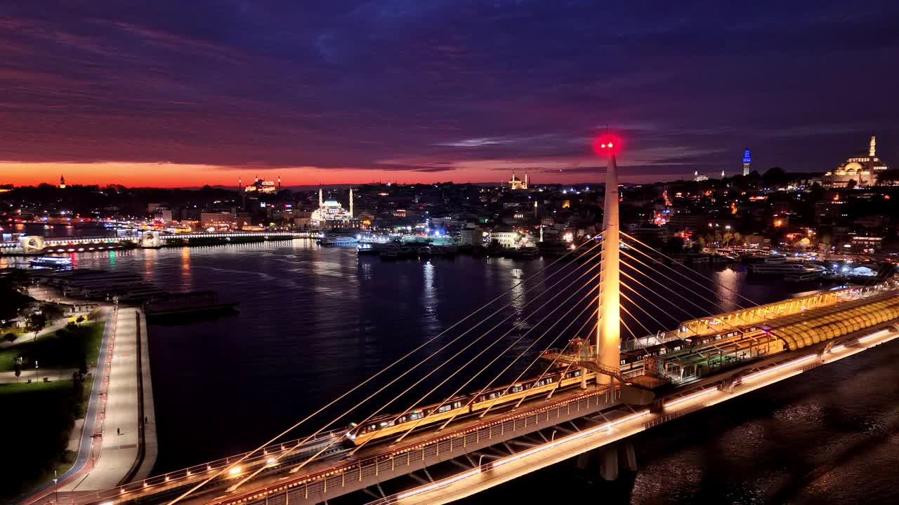 金色角大桥上的空中地铁列车被城市灯光照亮# metrobridge魔术#夜景#IlluminatedSkies #DroneViews视频素材