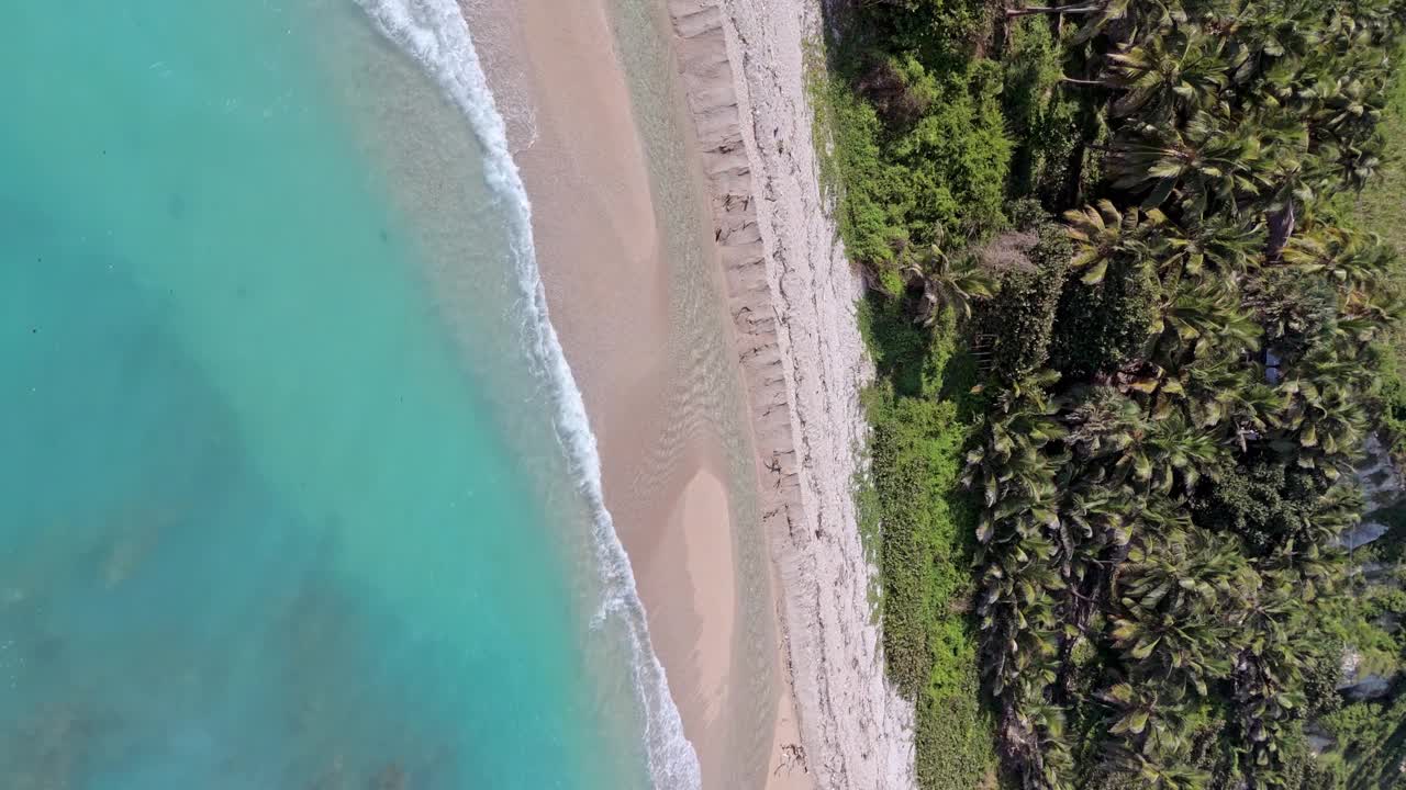 在夏季的洛斯帕托斯海滩海岸线上的蓝绿色海浪垂直视图在巴拉奥纳，多米尼加共和国。-航拍视频素材