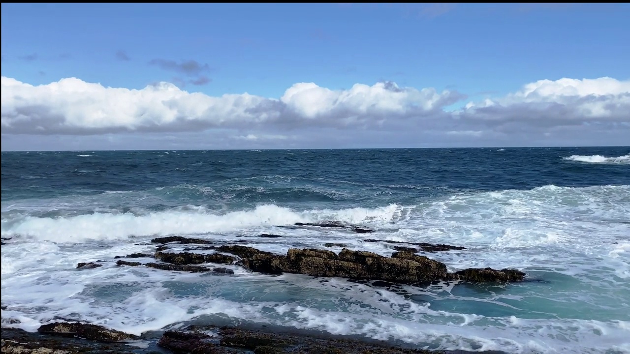 凯库尔斯基角，雷巴基半岛，巴伦支海，八月的海浪在海岸上映衬着蓝天视频下载