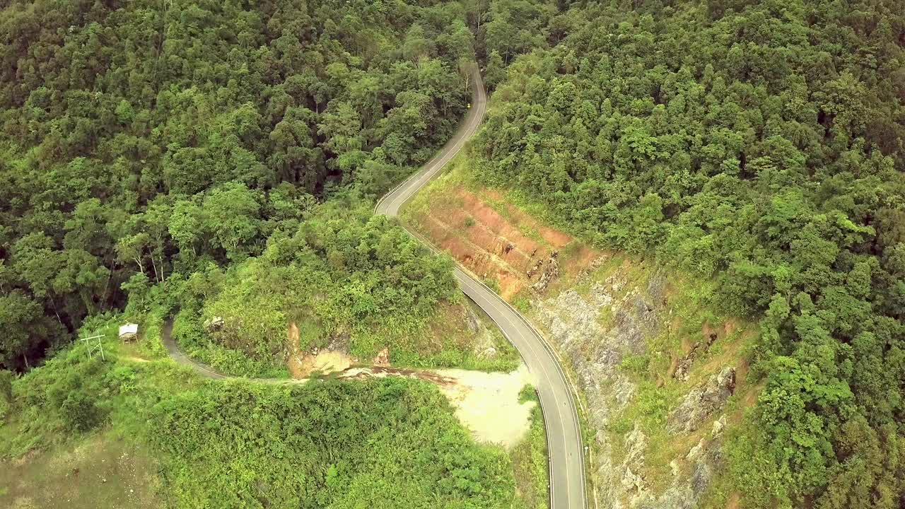 航空物流概念。一条蜿蜒的道路穿过充满活力的热带雨林，创造了一个迷人的自然和交通的融合。视频素材