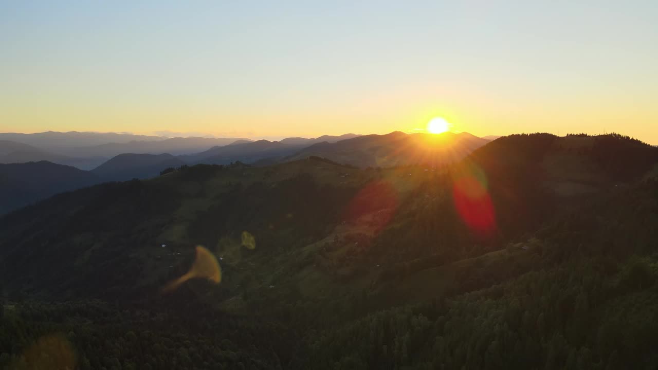 令人惊叹的山景鸟瞰图。在野生国家公园高地上明亮多彩的日落。黑暗的云杉树林被黄色的夕阳照亮视频素材