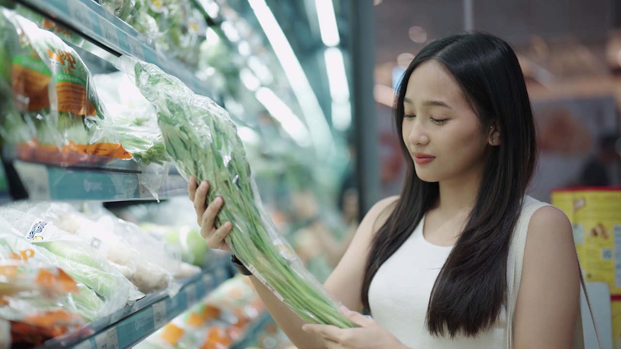 一位亚洲妇女在杂货店挑选蔬菜视频素材