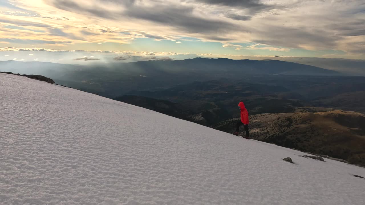 日落时分，一位女登山者正走在高海拔的山顶上视频素材