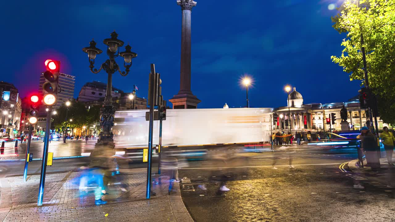 人群交通和通勤游客在特拉法加广场步行和过马路的时间流逝，这是英国伦敦市中心威斯敏斯特市夜间的公共广场城市景观视频素材
