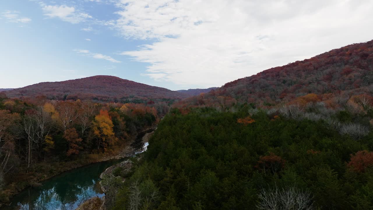 美国阿肯色州班亚德市雪松平原附近的秋天森林山谷和一条李溪河。空中倾斜拍摄视频素材