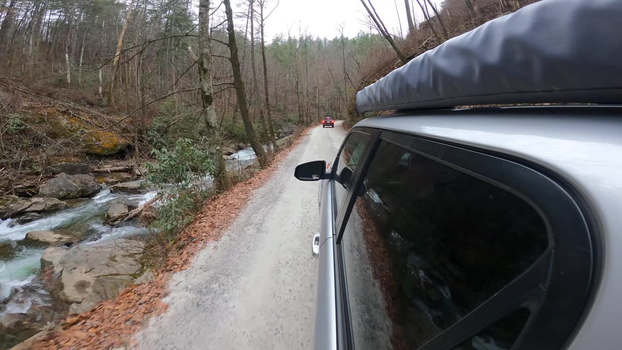 陆上车辆沿着风景秀丽的山溪附近的道路行驶视频下载