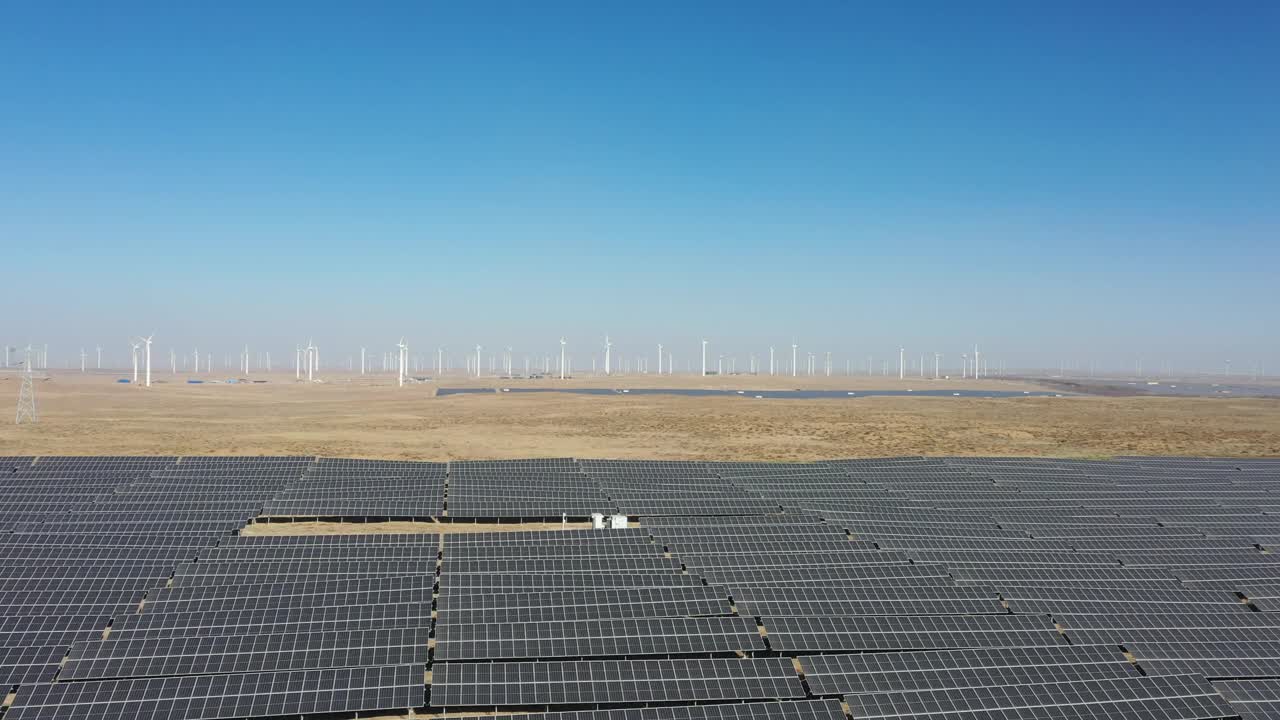 沙漠中太阳能光伏板和风力涡轮机的高角度鸟瞰图视频下载