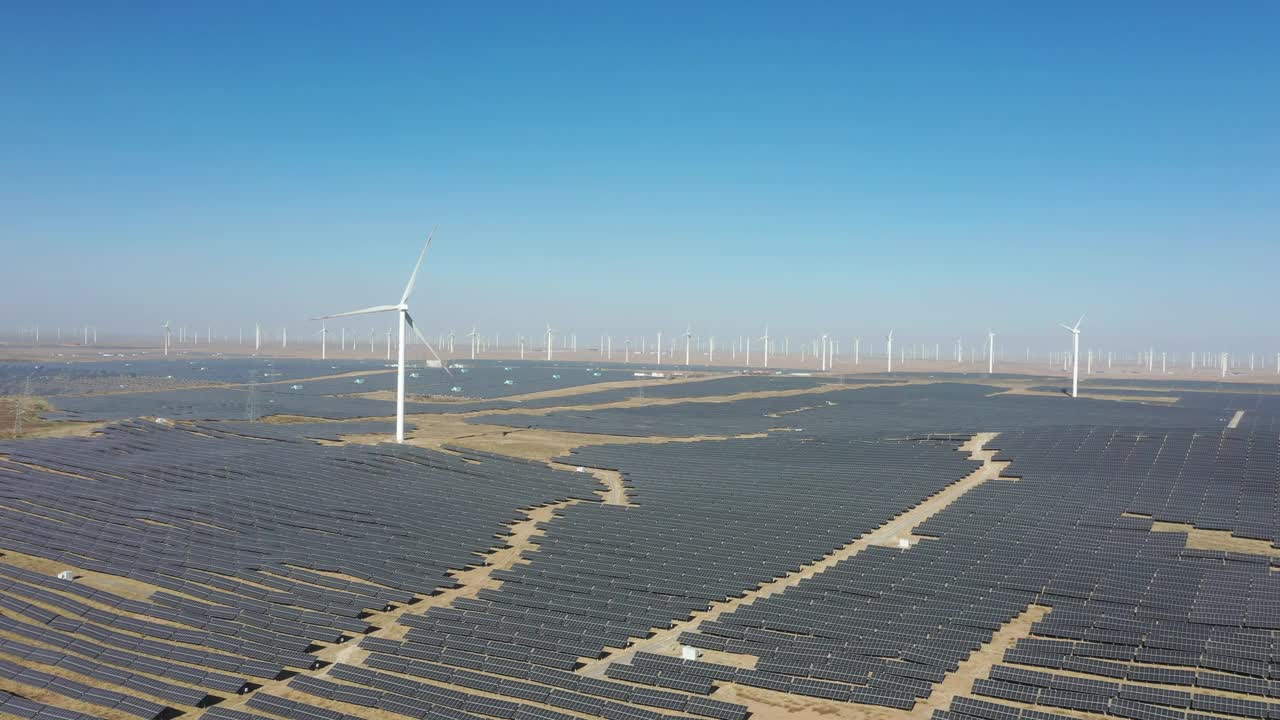 沙漠中太阳能光伏板和风力涡轮机的高角度鸟瞰图视频素材