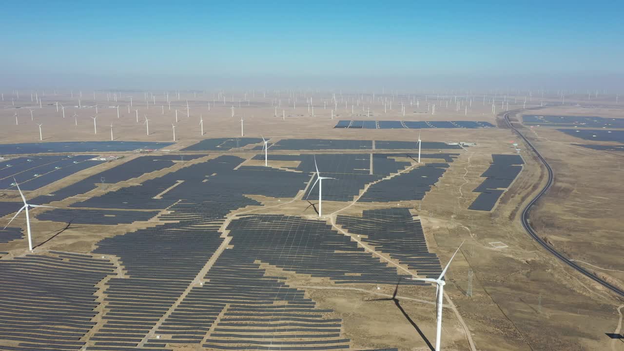 沙漠中太阳能光伏板和风力涡轮机的高角度鸟瞰图视频素材