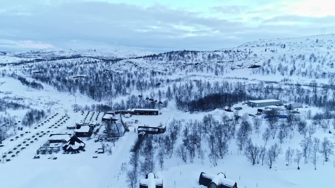 挪威基尔克内斯，白雪覆盖的雪地上的雪旅馆游戏小屋。空中回射视频素材