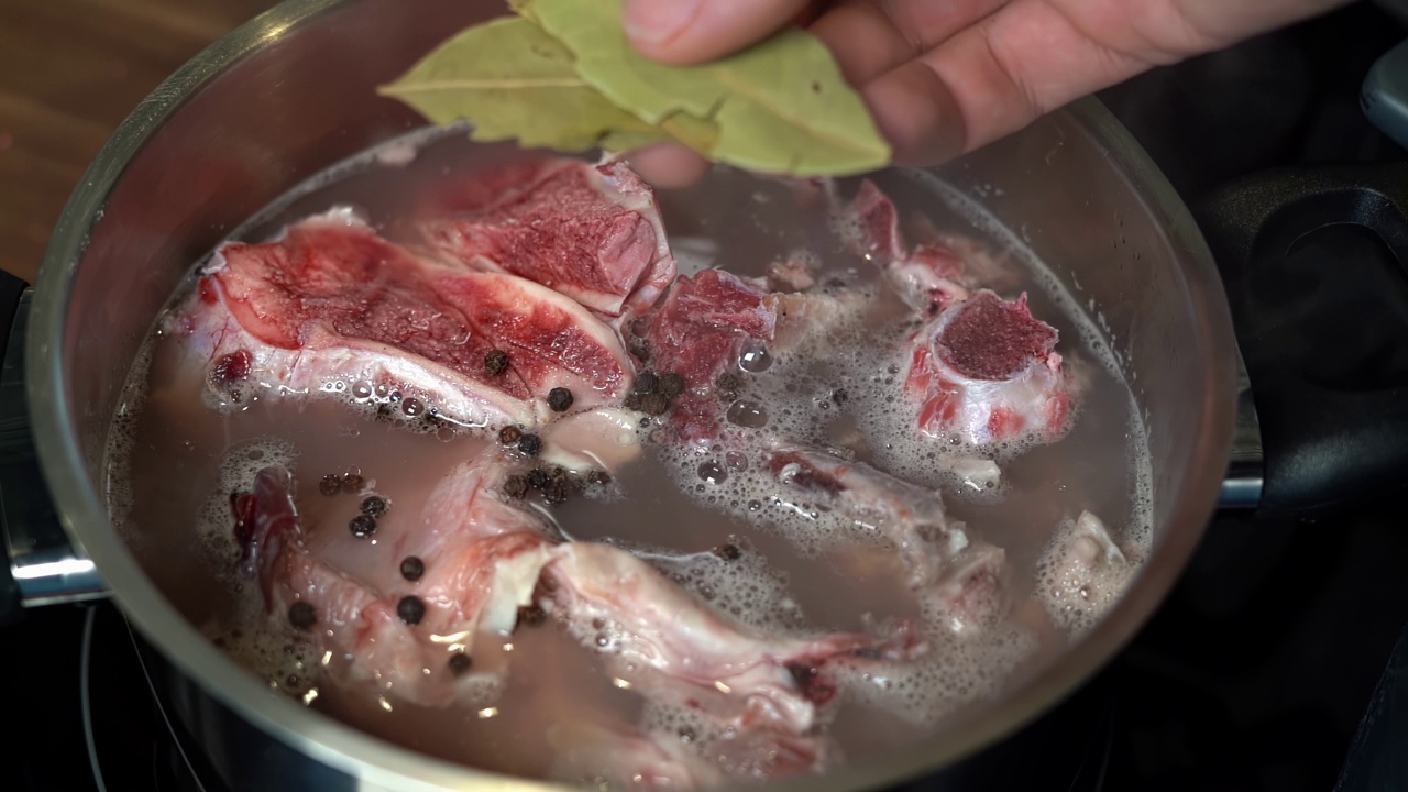 干月桂叶加入锅煮牛肉骨汤，慢动作视频素材