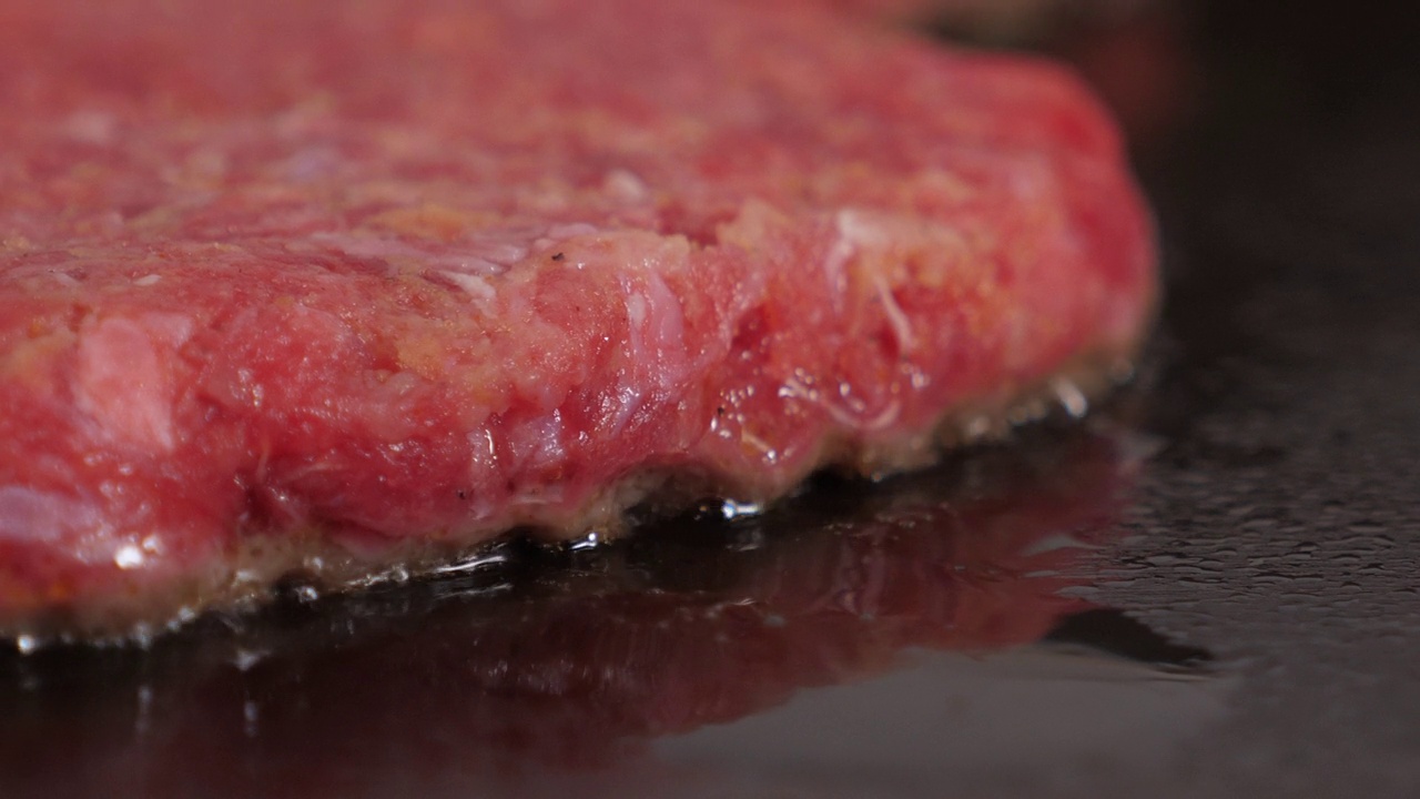 一个多汁的肉饼肉饼的特写正在餐厅的厨房里煎着。视频素材