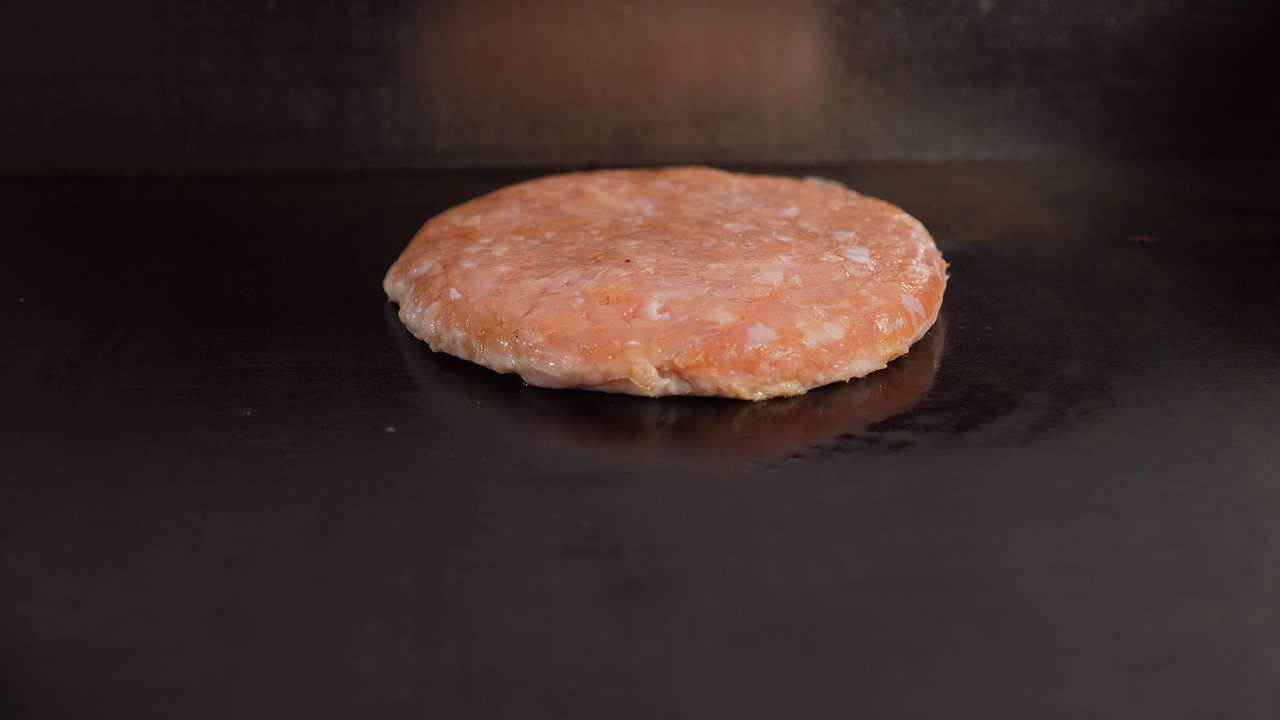 一家餐馆的厨房里正在煎鸡肉汉堡肉饼的特写。视频素材