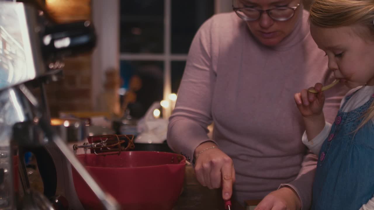 母亲和女儿一起做蛋糕的面团。视频素材