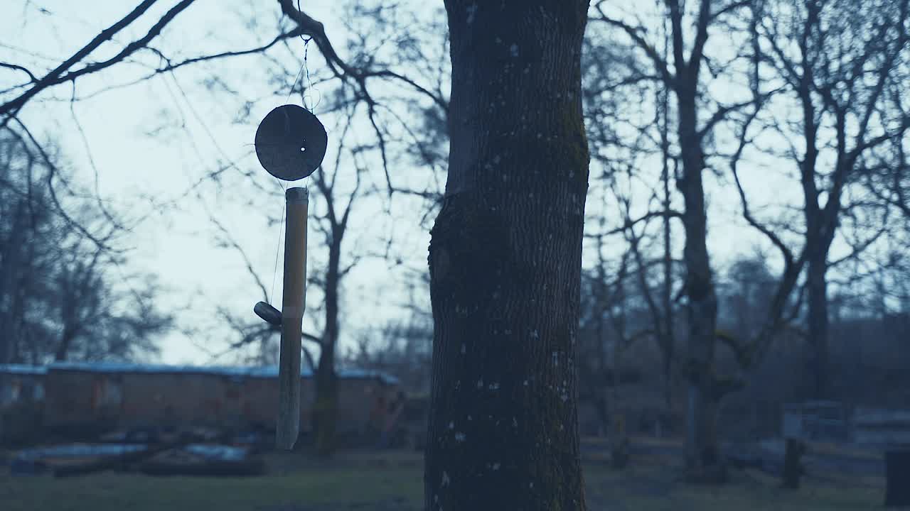 破碎的在风中摇摆的婴儿玩具，在黑暗的恐怖场景。废弃的村庄，谋杀案的目击者，犯罪现场。冬天寒冷的早晨。视频下载