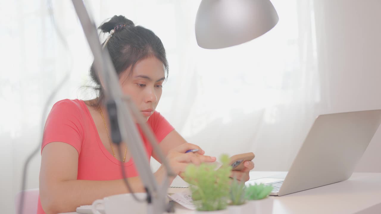 亚洲女性手用移动智能手机办公桌办公。在家计划财务账单。在家办公概念视频素材