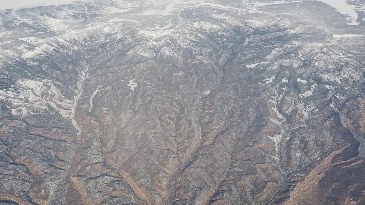 冬季在北美上空飞行。从飞机窗口看到的令人惊叹的风景。山区景观视频下载