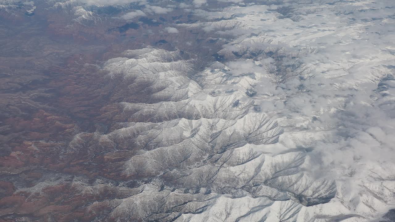 冬季在北美上空飞行。从飞机窗口看到的令人惊叹的风景。山区景观视频素材