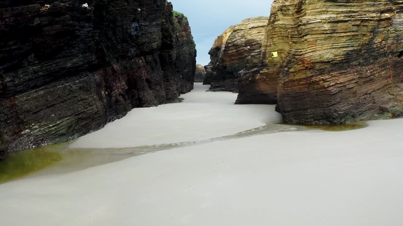 鸟瞰普拉亚海滩，它是加利西亚最美丽的海滩之一。水的力量在这个海滩上创造了海洞和石拱(Playa de las Catedrales, Lugo)。无人机视频视频素材