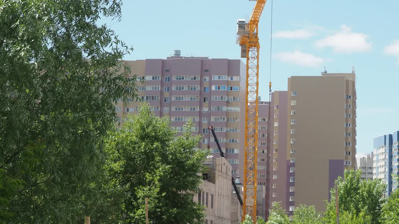 蓝天背景下的新建筑工地。钢框架结构、结构钢梁在施工现场建造大型建筑物。工程机械。现代城市视频素材