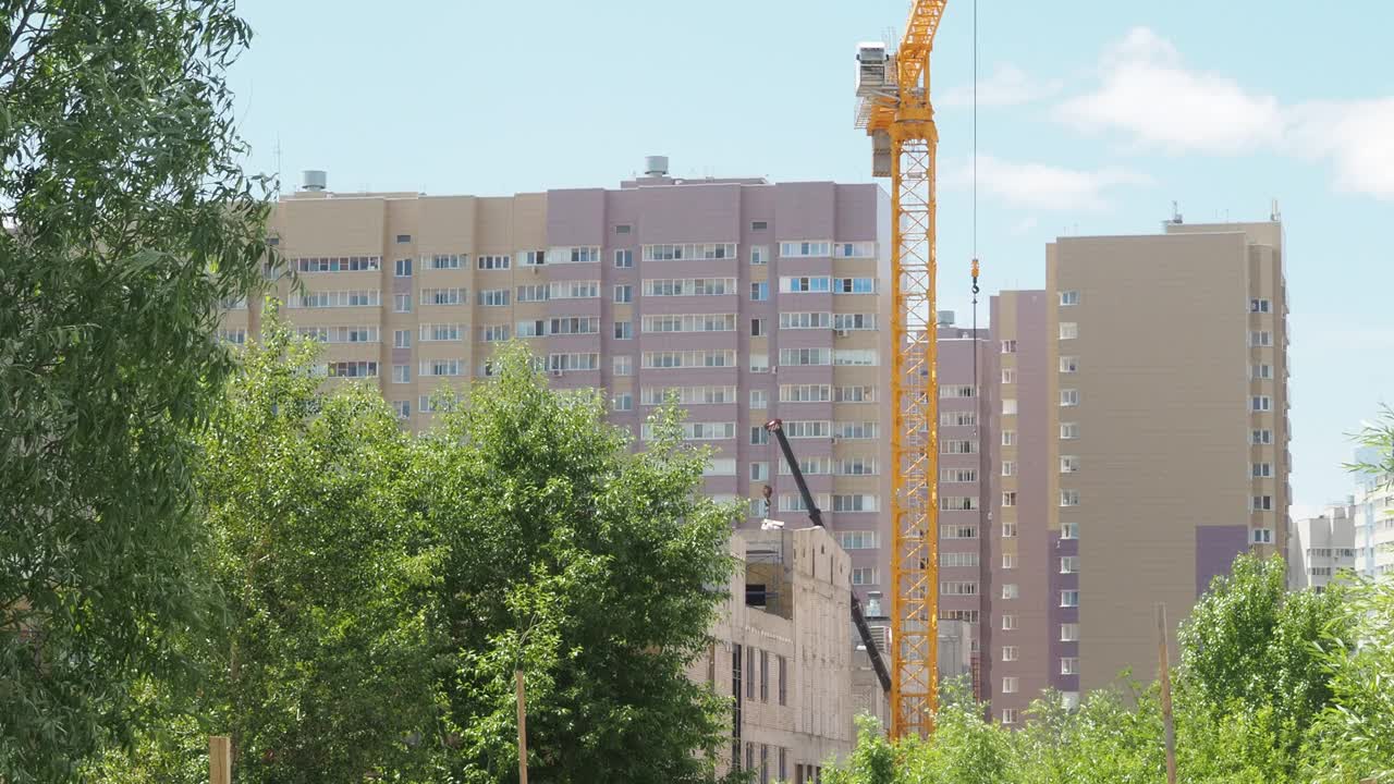 蓝天背景下的新建筑工地。钢框架结构、结构钢梁在施工现场建造大型建筑物。工程机械。现代城市视频素材